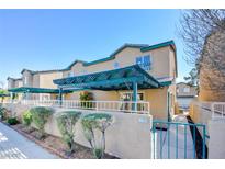 Charming townhouse with blue pergola, desert landscaping, and secured entry gate at 5720 Ritter Ln, Las Vegas, NV 89118