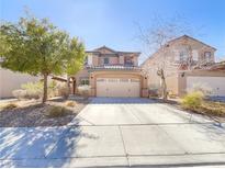 Inviting two-story home featuring a two car garage and desert landscaping at 6983 Positano Hill Ave, Las Vegas, NV 89178