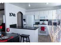 Eat-in kitchen featuring white cabinetry, black granite countertops, and modern appliances at 10553 Pine Pointe Ave # 201, Las Vegas, NV 89144