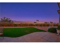 A backyard with a telescope, green grass, beautiful plants, and a stunning mountain view at 10716 Bennington Ct, Las Vegas, NV 89134