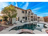 An inviting backyard featuring a private pool, covered patio, and lush landscaping at 1436 Via Merano St, Henderson, NV 89052