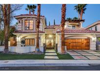 Elegant two-story stucco home featuring a red tile roof, gated entry, and a spacious two-car garage at 2508 Monarch Bay Dr, Las Vegas, NV 89128
