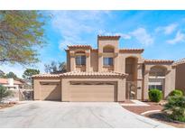 Charming two-story home boasts a three-car garage and a well-manicured front yard, with a tile roof and neutral colored stucco at 4708 Royal Sunset Ct, Las Vegas, NV 89130