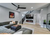 Contemporary living room with a large sectional sofa, electric fireplace, and modern decor at 649 Tranquil Jade St, Las Vegas, NV 89138