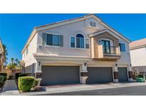 Multi-level townhome featuring private garage and a small balcony, with neutral stucco and tile roof at 10107 Sunset Palisades Way # 103, Las Vegas, NV 89183