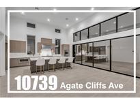 Modern, spacious kitchen with a large island, bar seating, stainless steel appliances, and plenty of natural light at 10739 Agate Cliffs Ave, Las Vegas, NV 89135
