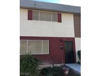 Two-story townhouse featuring neutral stucco, two windows and red trim at 146 Greenbriar Townhouse Way, Las Vegas, NV 89121