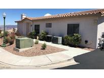 Beige single-story home with low maintenance landscaping, tile roof, and visible unit numbers near the entrance at 227 Big Horn Dr, Boulder City, NV 89005