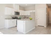 Modern kitchen features white cabinets, stainless steel appliances, and a large island at 3747 Lambent Ave, North Las Vegas, NV 89084