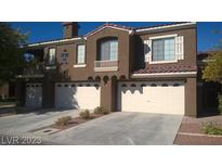 Modern townhome showcasing multi-car garage with a desert landscape and private balcony at 7290 Sheared Cliff Ln # 102, Las Vegas, NV 89149
