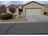 Charming single-story home features a well-maintained front yard and attached two-car garage at 7745 Fruit Dove St, North Las Vegas, NV 89084