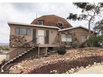 Unique dome-shaped house with stone accents and a sloped, rock-covered front yard at 1427 San Felipe Dr, Boulder City, NV 89005