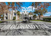 Stunning modern home featuring a circular driveway and fountain at 3860 Hildebrand Ln, Las Vegas, NV 89121