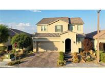 Charming two-story home featuring a brick driveway, neutral stucco, a tiled roof, and an attached two-car garage at 426 Port Reggio St, Las Vegas, NV 89138