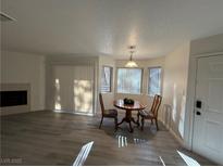Bright living area featuring a fireplace, a table, and natural light from large windows at 5044 S Rainbow Blvd # 106, Las Vegas, NV 89118