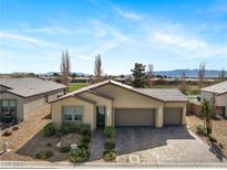 Inviting single-story home featuring a three-car garage and desert landscaping at 5467 Eleganza Ave, Pahrump, NV 89061