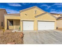 Single-story home with a two-car garage, desert landscaping, and a blue sky overhead at 5934 Reflection Point Ct, Las Vegas, NV 89110