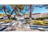 Charming single-story home with a well-maintained lawn and driveway, surrounded by mature trees and greenery at 6944 Emerald Springs Ln, Las Vegas, NV 89113