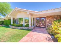 Charming home featuring unique front door, stone accents, and well-manicured landscaping at 6980 Mira Vista St, Las Vegas, NV 89120