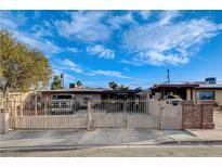 Modest single story home with an expansive gated front yard and covered parking area at 1808 Walnut Ave, Las Vegas, NV 89101