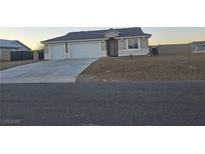 Charming single-story home featuring a two-car garage and low maintenance desert landscaping at 5051 Fairmont St, Pahrump, NV 89061
