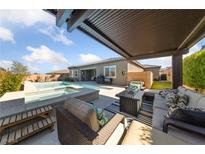 Relaxing backyard oasis with a covered patio and a sparkling swimming pool and spa for outdoor enjoyment at 6192 Lautman Ridge Ct, Las Vegas, NV 89141