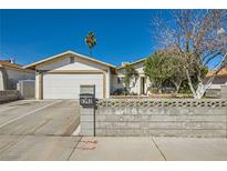 Charming single-story home with a low concrete wall, palm tree and well-maintained front yard on a sunny day at 6312 Portola Rd, Las Vegas, NV 89108