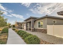 Well-maintained exterior showcasing the home's design, complemented by manicured landscaping and a paved pathway at 758 Marigold Sunrise St, Henderson, NV 89011