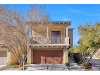 Inviting two-story home featuring a balcony, complemented by a well-maintained front yard and attached garage at 9823 Lime Tree St, Las Vegas, NV 89178