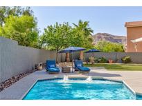 Sparkling pool area with dual lounge chairs, umbrellas, and mountain views at 10288 Grizzly Forest Dr, Las Vegas, NV 89178