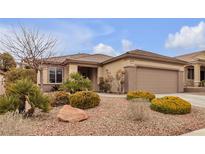 Charming single-story home featuring a two-car garage and desert landscaping with decorative rock and mature shrubs at 2832 Goldcreek St, Henderson, NV 89052
