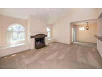 Cozy living room featuring a fireplace, neutral carpet, and arched windows with recessed seating at 3145 E Flamingo Rd # 2119, Las Vegas, NV 89121