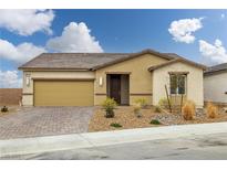 Inviting single-story home featuring a well-manicured front yard, brick driveway and attached two-car garage at 4096 E Cactus Canyon Dr, Pahrump, NV 89061