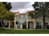 Inviting two-story condo building with well-maintained landscaping and exterior stairs at 4865 S Torrey Pines Dr # 106, Las Vegas, NV 89103