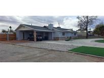 Charming single-story home featuring a carport, brick accents, and landscaped front yard on a large lot at 5231 Smoke Ranch Rd, Las Vegas, NV 89108