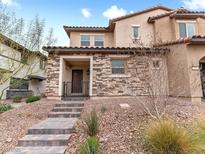 Charming two-story home featuring a stone facade, covered porch, and well-maintained desert landscaping at 715 Pickled Pepper Pl, Henderson, NV 89011