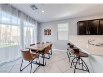 Bright dining area with modern table, chairs and natural light from large sliding glass doors at 8502 Torozo Ave, Las Vegas, NV 89149