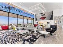 Bright, open living room with floor-to-ceiling windows and modern decor and gourmet kitchen at 11 Cloud Chaser Blvd, Henderson, NV 89012