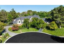 Expansive two-story home featuring a dark gray roof, beautiful landscaping, and mature trees at 3001 Astoria Pines Cir, Las Vegas, NV 89107