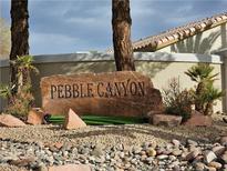 Community entrance sign with mature trees and xeriscaping in the Pebble Canyon neighborhood at 3025 Cooper Creek Dr, Henderson, NV 89074