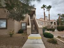 Inviting condo with mature landscaping, stairs to a second-story entrance, and desert surroundings at 3455 Erva St # 219, Las Vegas, NV 89117