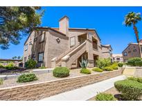 Well-maintained condo building with a desert landscape and block wall at 3455 Erva St # 219, Las Vegas, NV 89117