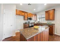 Modern kitchen featuring stainless steel appliances, granite countertops, and a center island with rich wood cabinetry at 3756 Prairie Orchid Ave, North Las Vegas, NV 89081