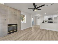 Open living space featuring a fireplace, hardwood floors, and an eat-in kitchen with new appliances at 4012 Cape Sand Dr, Las Vegas, NV 89108