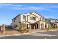 Two-story home with tan stucco, brown tile roof, arched entry, and two-car garage at 4050 Peaceful Dune St, Las Vegas, NV 89129