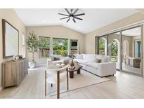 Bright, modern living room with white sofa, large windows, and sliding glass doors to the outdoor area at 441 Beautiful Hill Ct, Las Vegas, NV 89138