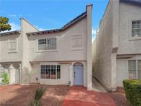 Charming two-story townhome featuring a stucco facade, red walkway, and a bright blue front door at 5383 Mountain Vista St # 20, Las Vegas, NV 89120