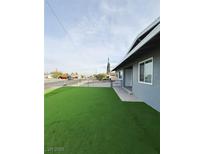 Well-maintained home with artificial turf and chain link fence for curb appeal and easy yard maintenance at 5409 Holmby Ave, Las Vegas, NV 89146