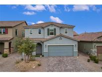 Two-story home featuring a paver driveway, a gray exterior, and desert landscaping at 7532 Lush Oasis Ave, Las Vegas, NV 89113