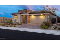 Beautiful single-story home featuring a stone facade, brick driveway, and a well-maintained front yard at 912 Calluna Hills Ln, Las Vegas, NV 89138